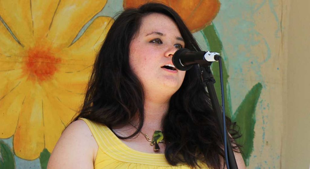 woman singing on outdoor stage