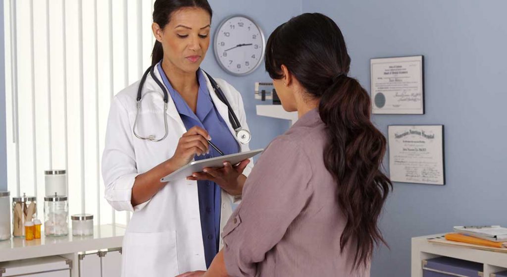 female patient receiving exam from female doctor in an exam room