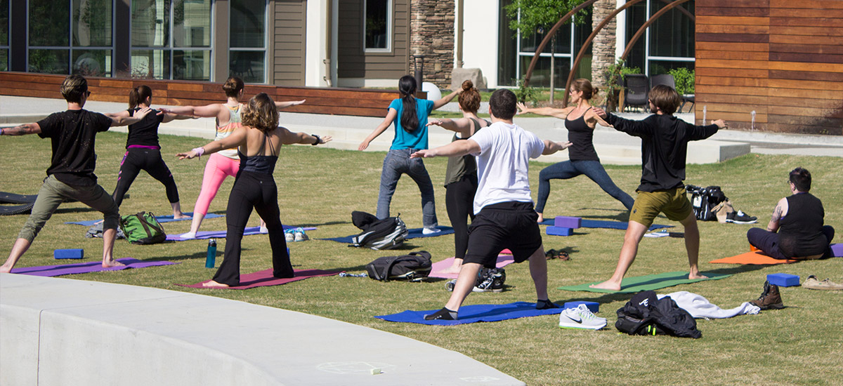 group of adults doing yoga in an outdoor courtyard