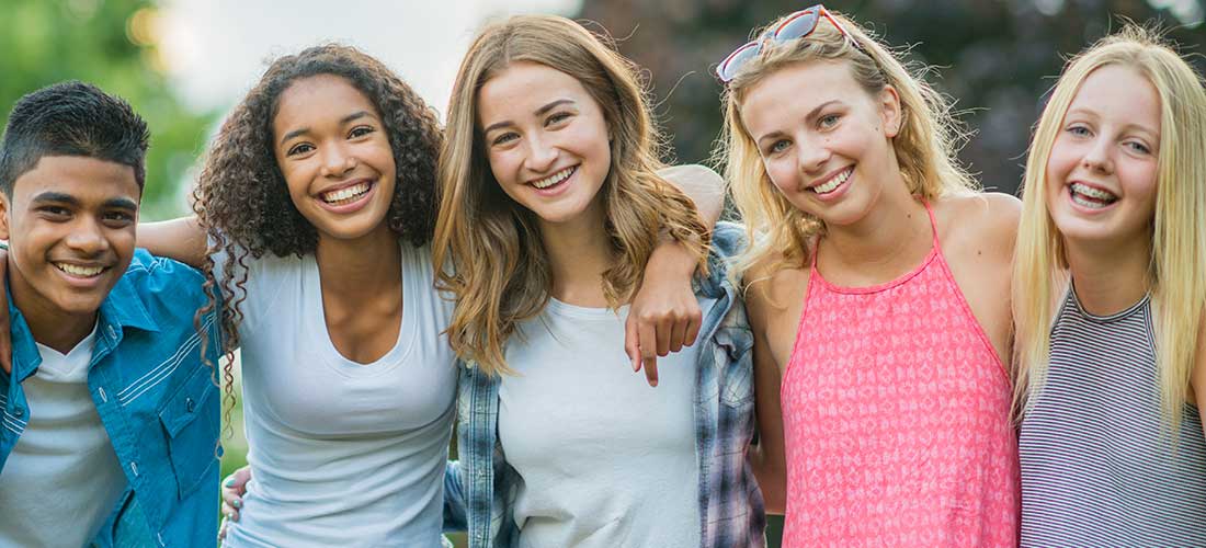five teens smiling at camera