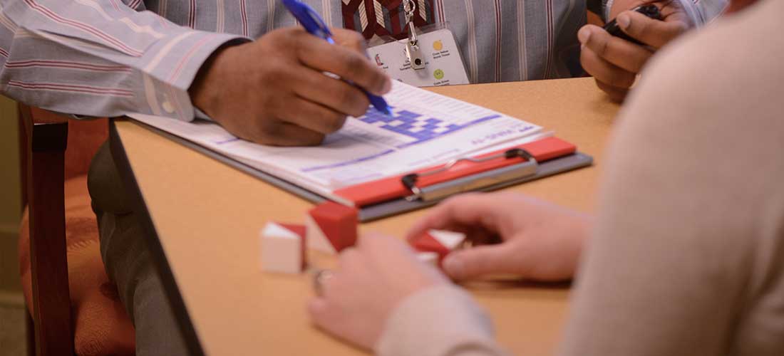 woman arranging small blocks in a pattern while being timed