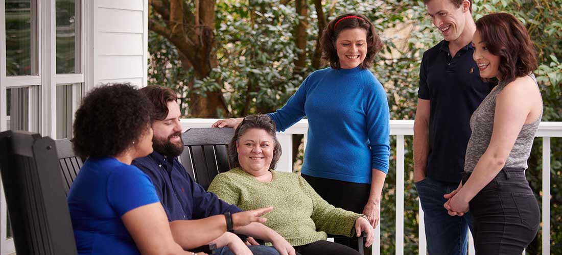 group of men and woman talking on the porch