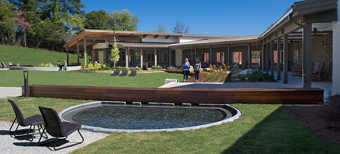 two people walking on courtyard boardwalk toward reflecting pool