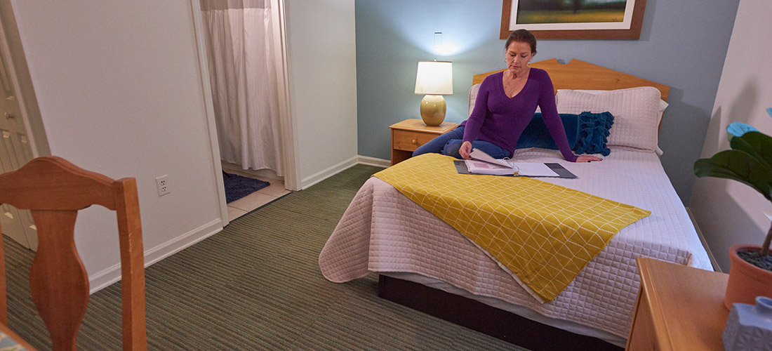 woman sitting on bed reading