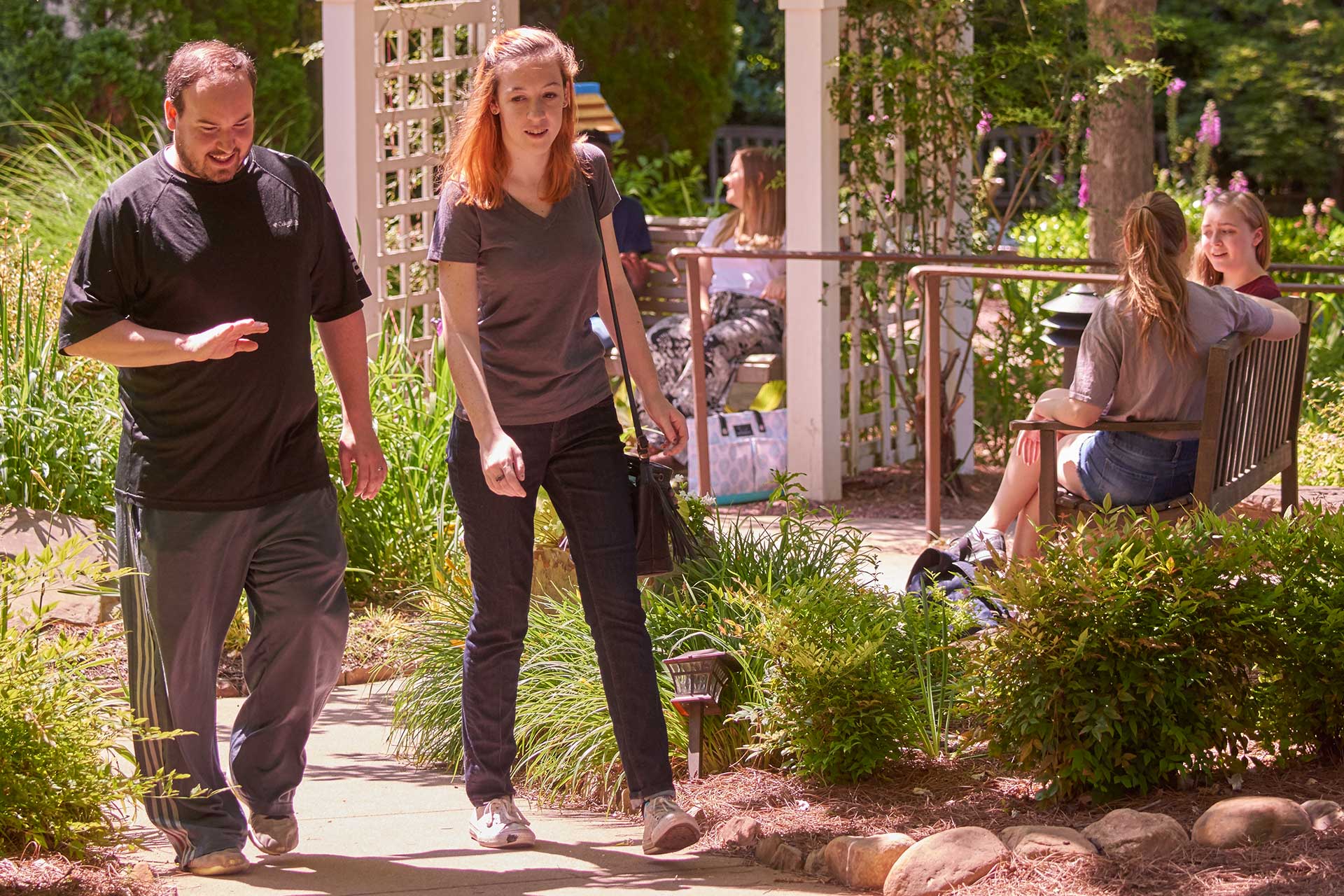 man and woman walking on path in courtyard