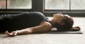 Woman lying on back practicing DBT skill sensory body awareness