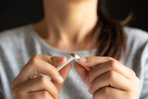 woman in mental health treatment breaking cigarette