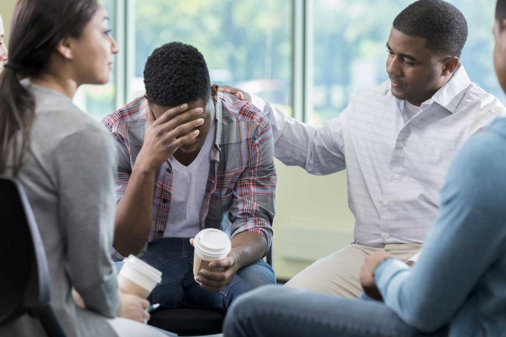 adults in support group showing support