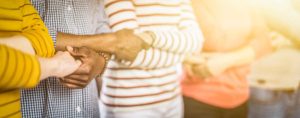 people in a row with linked arms showing support for suicide prevention