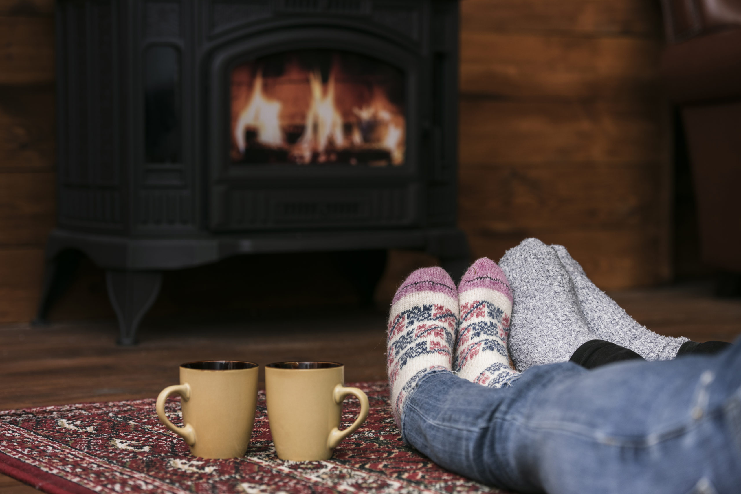 couple warming feet by fireplace