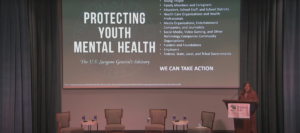 CDC's Dr. Deb Houry on stage at podium presenting slides about protecting youth mental health