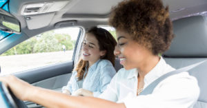 Two women riding together in a car smiling