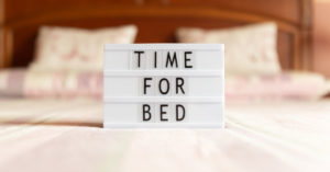 a lightbox with the words "Time for Bed" sits a top of a bed in a bedroom