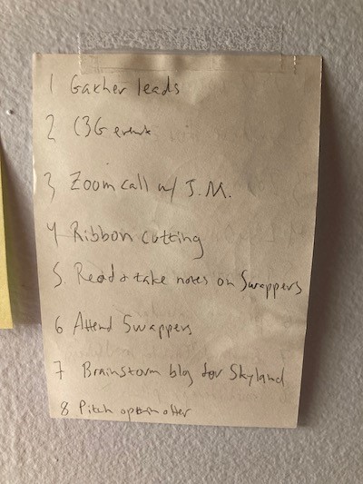 An image of a piece of paper with eight items listed, taped to a wall. The paper reads:
1 - Gather leads
2 - C3G event
3 - Zoom call with JM
4 - Ribbon Cutting
5 - Read and take notes on Swappers
6 - Attend Swappers
7 - Brainstorm blog for Skyland
8 - Pitch open after