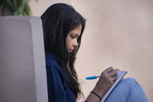 teen girl writing in journal as part of prolonged exposure therapy for trauma