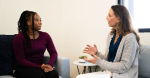 a young woman and a therapist talk during an individual psychotherapy session