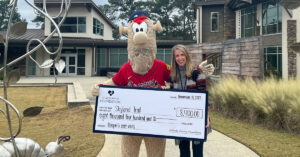 Blooper, Atlanta Braves mascot, presents a check for $8,400 to Katie Dozier, Vice President of Development for Skyland Trail