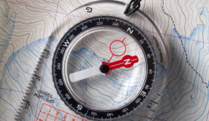 acrylic compass on top of a map