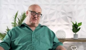 portrait of Andreas wearing green shirt and glasses
