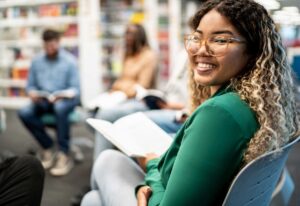 teen girl sitting in a chair in a circle with other teens facing camera and smiling