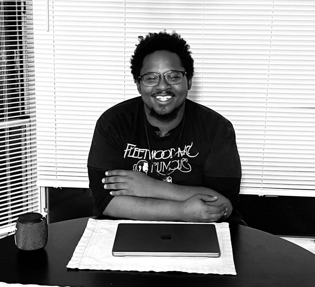 photo of adult program graduate Cornelius sitting at a table smiling