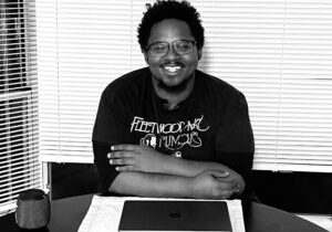 photo of adult program graduate Cornelius sitting at a table smiling